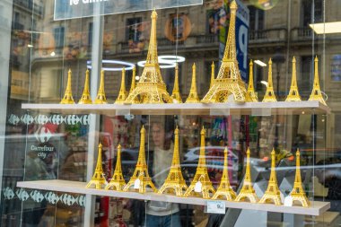 Paris, Fransa - 30 Ekim 2025: Eiffel Kulesi satılık biblo seti. Mağaza sokağında altın renkli hediyeler