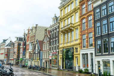 Amsterdam Hollanda - 28 Ekim 2025: Amsterdam City Canal yakınlarında renkli evler. Sokak mimarisi. Tarihi merkezde Eski Bina 'yı gezmek. Bir sürü bisiklet parkı var.