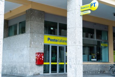 Poste Italiane ön cephesi kırmızı posta kutusuyla İtalyan postanesi. Bina girişi. Sarı logo işareti. İtalya, Rimini - 13 Temmuz 2025