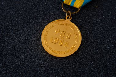 Golden medal pro fide et patria with the coat of arms of Ukraine and a yellow-blue ribbon. 988-1988 first division of the Ukrainian National Army. Ukraine, Kyiv - August 4, 2025