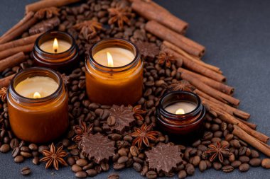 Kavanozda soya kokulu mum. Kahve çekirdekleri anason, tarçın baharatları. Noel havası mumları yanan arka planda. Çikolatalı şeker..