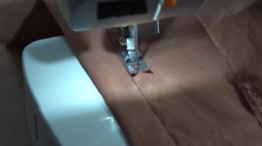 Dikiş makinesi, ayağınızı kapatın ve kumaşa dikiş atın. Makine video ile çalışıyor. İğne dikiş ipliği