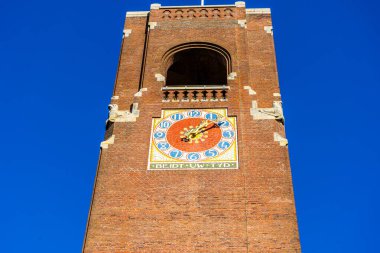 Amsterdam, Hollanda - 27 Ekim 2025: Şehir merkezinde saat kulesi. Eski tuğla bina bir dönüm noktası. Mavi gökyüzü arkaplanı