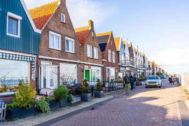 Volendam, Hollanda - 27 Ekim 2025: Fish Village Caddesi 'ndeki yol arabası eski renkli evler inşa ediyor.