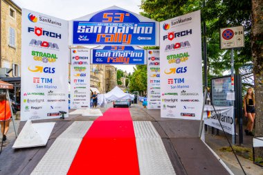 San Marino rali yarışı. Kürsüde kırmızı halı. Sponsor logosu, reklam tabelası. İtalya, San Marino - 13 Temmuz 2025