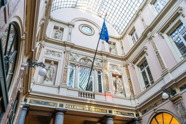 Saint-Hubert Kraliyet Galerisi. Bayrak AB. St. Hubert 'in galerilerindeki alışveriş merkezinin çatısında. Eski bina mimarisi. Brüksel, Belçika - 28 Ekim 2025