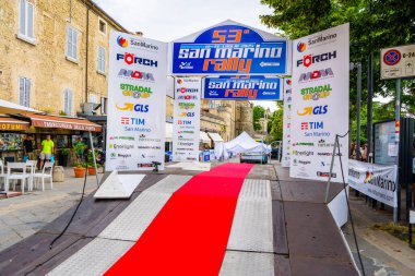 San Marino ralli şehri. Kürsüde kırmızı halı. Yarış sponsoru logosu, reklam tabelası. İtalya, San Marino - 13 Temmuz 2025