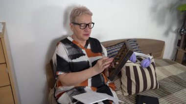 Tahta bir abaküse güvenerek. Son sınıf öğrencisi kadın yatakta otururken konuşuyor ve not defterine yazıyor..