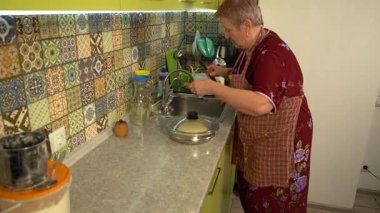 Ev mutfağında yemek pişiren son sınıf kadını. Para kazan.