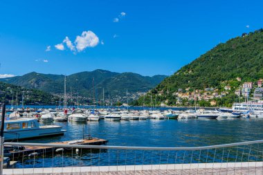 Como Gölü rıhtımında yaz günü tekneler. İtalyanların seyahat ettiği çok renkli evler. İtalya, Como - 17 Temmuz 2025