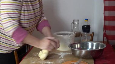 Un içinde hamur yoğuran yaşlı bir kadının elleri. Evde yemek pişirmek.