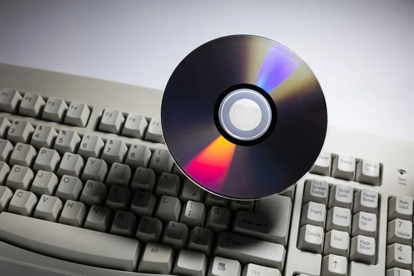 Teclado do computador e disco de DVD — Fotografia de Stock