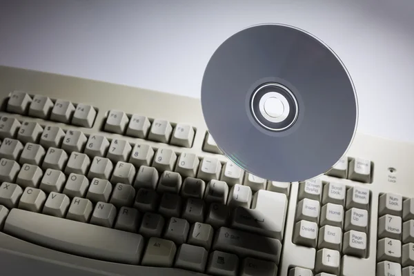 Teclado do computador e disco de DVD — Fotografia de Stock