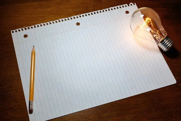 Jegyzetfüzet papír és a villanykörte — Stock Fotó