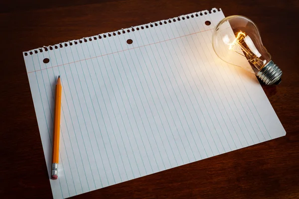 笔记本纸和灯泡 — 图库照片