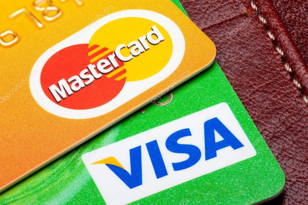 Estonia - September 24, 2014. Visa and Mastercard credit cards with the leather wallet on the background. Mastercard and Visa are the biggest credit card companies in the world.