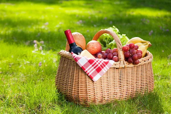 Picknickkorb mit Essen auf grünem Gras. — Stockfoto