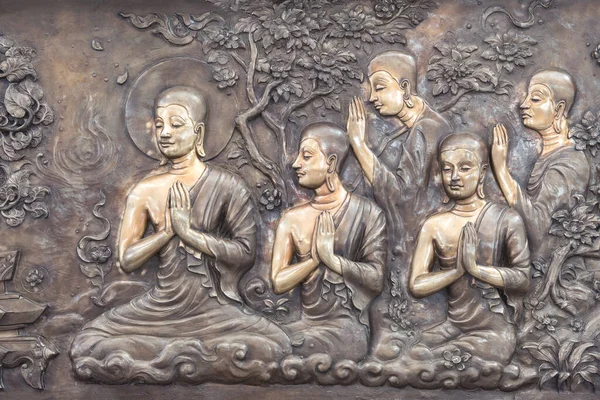 Buda 'nın Tayland' daki tapınak duvarına bakır oyması. Buda heykeli Buda 'nın tarihi hakkında bir hikaye anlatıyor..