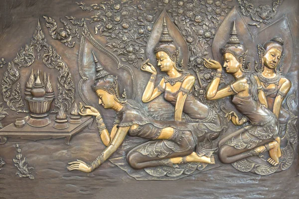 Buda 'nın Tayland' daki tapınak duvarına bakır oyması. Buda heykeli Buda 'nın tarihi hakkında bir hikaye anlatıyor..
