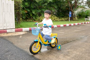 Bisiklet süren Asyalı küçük çocuk. 