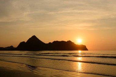 Dağ ve denizin üzerinde dramatik gün batımı.