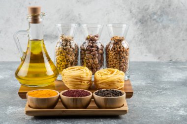 Çiğ makarna ve baharatlı bir şişe yağ.