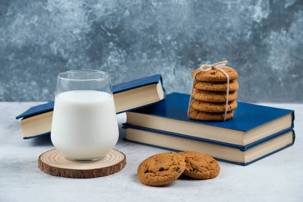 A glass cup of milk with chocolate cookies on a wooden board — Stock Photo, Image