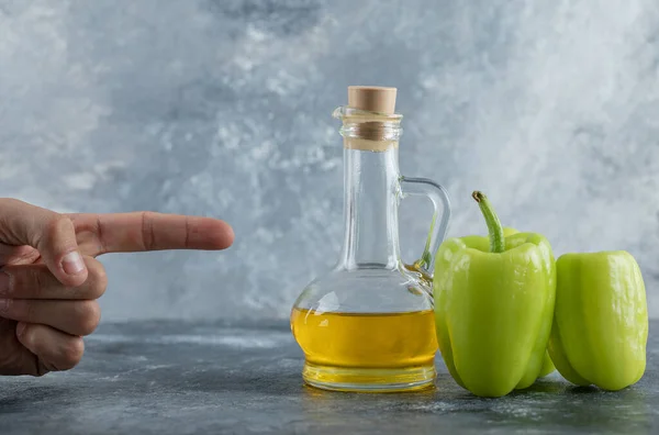 Man wijzend vinger naar de peper en olie — Stockfoto