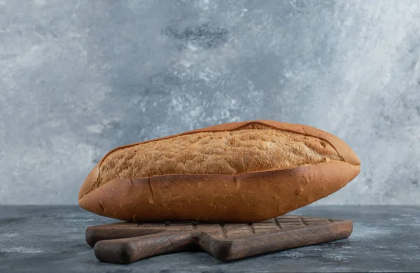 Zdjęcie bochenka chleba na desce do krojenia drewna — Zdjęcie stockowe