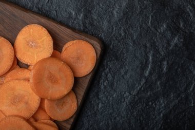 Siyah arka planda dilimlenmiş havuçların yakın plan fotoğrafı.