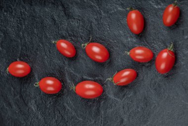 Siyah arkaplanda küçük vişne domatesleri