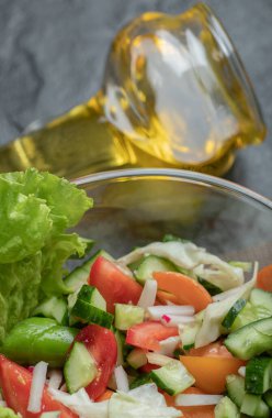 Siyah arka planda sebze salatası ve yağı kapat.