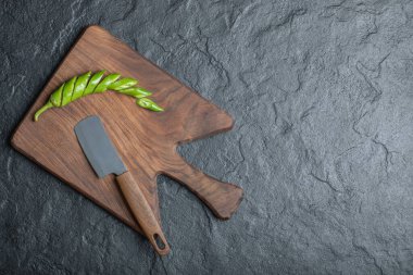 Tahta kesme tahtasının üzerinde yeşil dilimlenmiş acı biber.