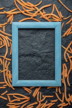 Julienne Havuçları mavi çerçevenin etrafında siyah arka planda