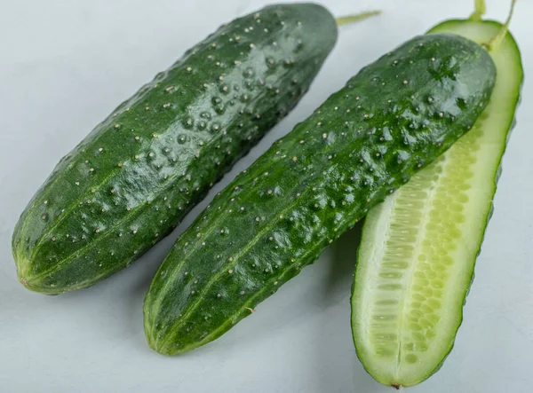 Close-up van verse komkommers en plakjes geïsoleerd op witte achtergrond. — Stockfoto