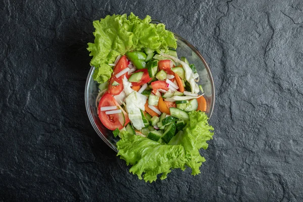 녹색 잎의 야채 샐러드와 야채가 섞여 있습니다. 검은 색 위의 위도. — 스톡 사진