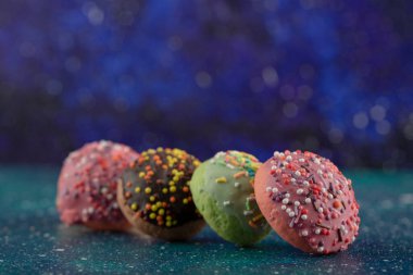 Mavi arka planda serpiştirilmiş renkli küçük çörekler