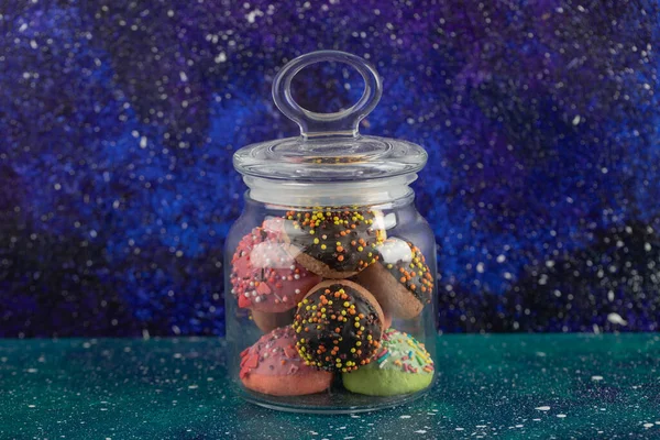 Ένα γυάλινο βάζο γεμάτο μικρά πολύχρωμα ντόνατς — Φωτογραφία Αρχείου