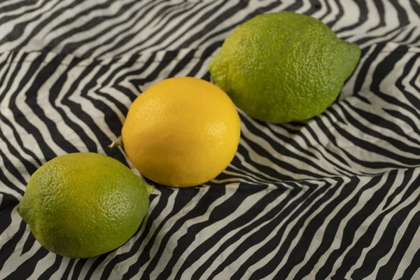 Limón amarillo y verde sobre un hermoso mantel —  Fotos de Stock