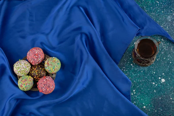 Beignets doux colorés avec une tasse de thé — Photo