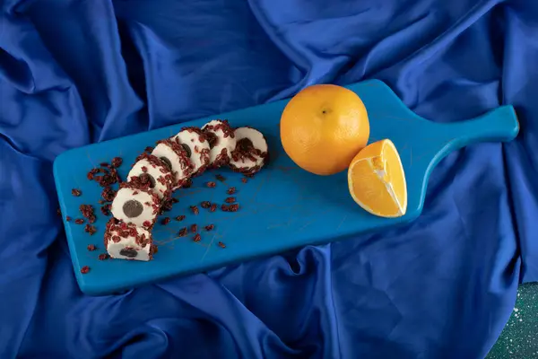 Dessert sucré tranché aux fruits secs sur une planche bleue en bois — Photo