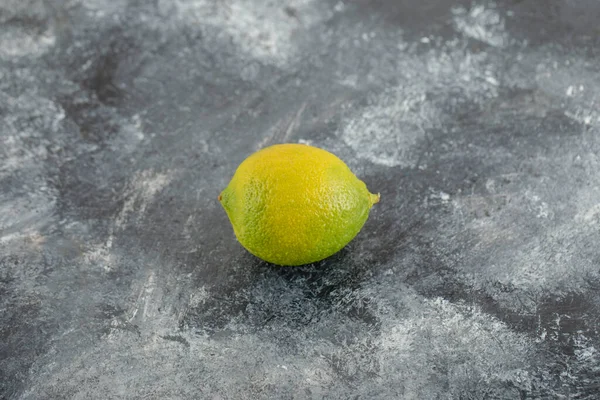 Un limón verde maduro sobre un fondo de mármol —  Fotos de Stock