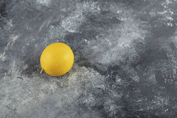 Un limón amarillo maduro sobre un fondo de mármol — Foto de Stock