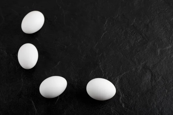 Huevos blancos frescos sobre fondo negro — Foto de Stock