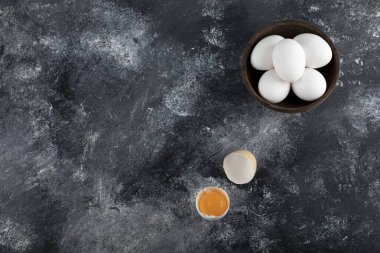 Bir kase beyaz yumurta ve mermer arka planda yumurta sarısı