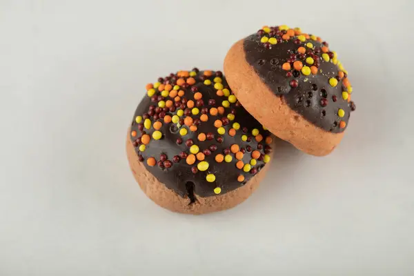 Chocolate sweet doughnuts with colorful sprinkles — Stock Photo, Image