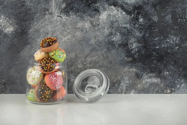 Ένα γυάλινο βάζο γεμάτο μικρά πολύχρωμα ντόνατς — Φωτογραφία Αρχείου