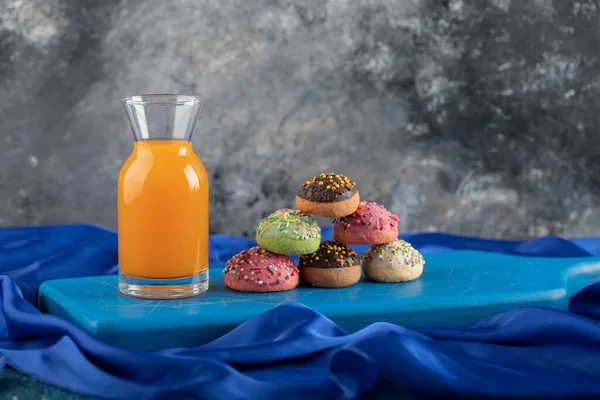 Een glazen fles sap met kleurrijke donuts — Stockfoto