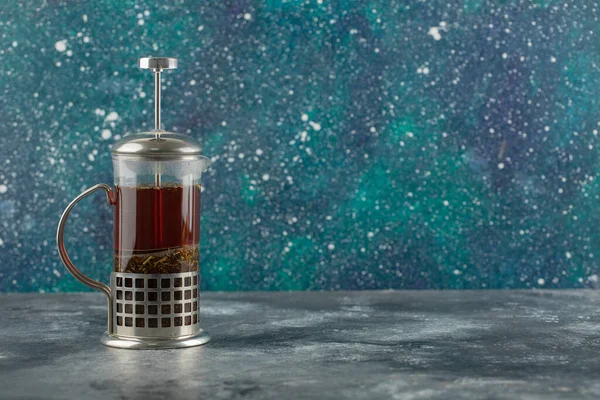 A glass teapot with hot drink on a bright background — Stock Photo, Image