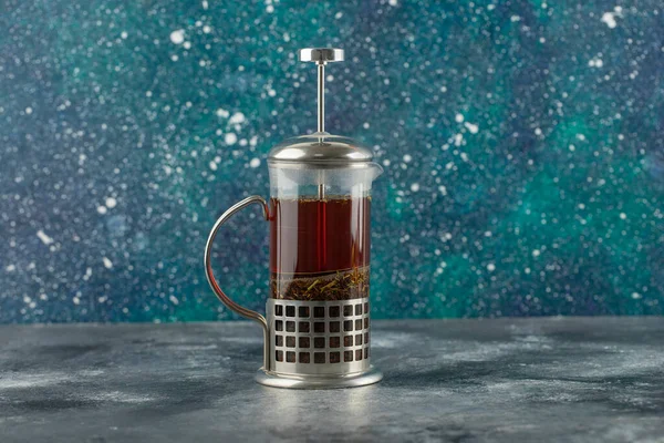 A glass teapot with hot drink on a bright background — Stock Photo, Image